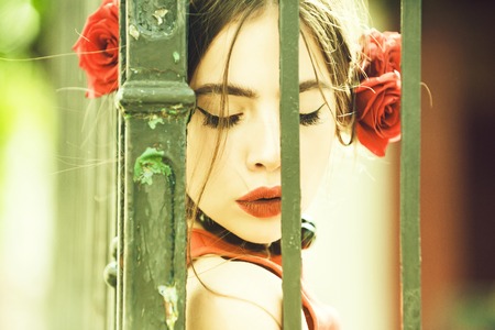 female makeup. spanish woman with rose in hair at iron fenceの写真素材