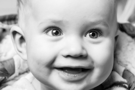 Happy child. happy baby boy, little child, with blond hair and big eyes on adorable smiling face, has cute cheeks on blurred background, childhood and happinessの写真素材