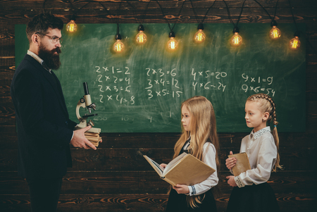 Talented child usually needs coaching. Talented schoolkid is doing his art homework in classroom at school. Teacher and elementary age children drawing at classroom in schoolの写真素材