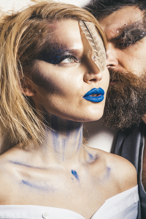 Paint party. Woman and man with art makeup for paint party. Couple in love styled for paint party. Paint party and colors festival. Getting ready to go outの写真素材