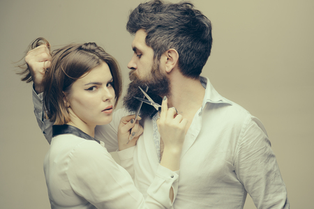 Beard makes your appearance more masculine and brutal. Beard care tricks keep facial hair look resplendent. Masculinity concept. Girl barber with scissors cutting beard hair brutal bearded hipsterの写真素材