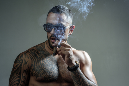 Sexy man with bare torso. Brutal handsome man with tattooed body. Men tattoo casual fashion. Portrait of brutal handsome male model outdoor. Muscular athletic sexy male with naked torso.の写真素材