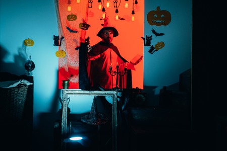 Halloween dresses and witch costumes and witch hats. Magic hat. Best ideas for Halloween. Jack-o-lanterns. Happy father on halloween background with magik book. Magic pumpkin. Man Horror faces.の写真素材