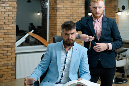 Senior man visiting hairstylist in barbershop. Professional hairstylist in barbershop interior. Hair Preparation is just for the dashing chap. Hair style and hair stylist.の写真素材