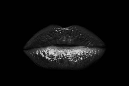 Sexy lips beautiful female closed mouth red color with gloss or lipstick isolated on black backgroundの写真素材