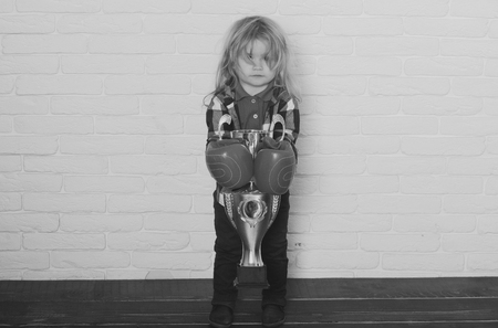 kid wearing boxing glove, boy boxer winning golden champion cupの写真素材