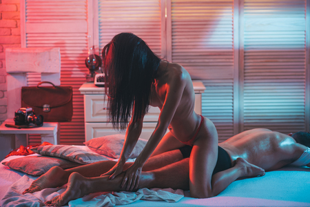 Effective Massage Techniques. Massage Relax. Ethics for Massage. Sexy woman in underwear in the bed make Massage to man.の写真素材
