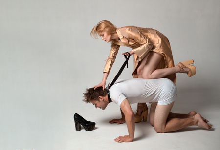 Sexy lady on top. Bondage and Discipline. Dominate obey undress seduce a partner. Thematic bdsm. Obeys man. Gender domination and role games.の写真素材