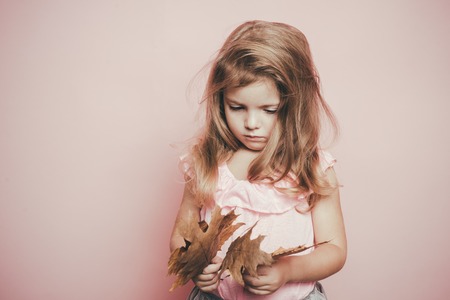 Autumn mood and the weather are warm and sunny and rain is possible. Cute little child girl holding...