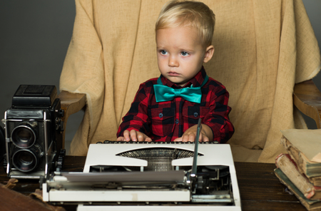 Baby boy type on retro typewriter at desk. It makes me feel so retro.の写真素材