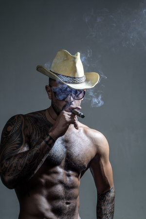 Colombian cartel. Cigar. Muscular latin lover. Portrait of brutal handsome latin man. Stylish man looking away. Men fashion portrait. Confident man.の写真素材