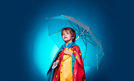 Sale for entire autumn collection, incredible discounts and wonderful choice. Cute little child boy are getting ready for autumn. Cheerful boy in raincoat with colorful umbrella. Kid in rain.の写真素材