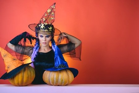 Pretty young woman in witch costume. Surprised woman in witches hat and short dress. Glamour Fashion Sexy Vampire Lady with witch costume. Halloween party and holiday concept.の写真素材