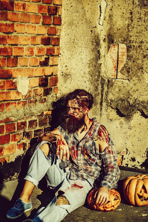 Zombie man with halloween pumpkinsの写真素材