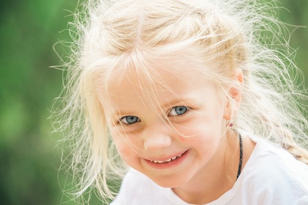 Feeling free and happy. Little girl wear hair in plaits. Small girl with blond hair. Happy little...