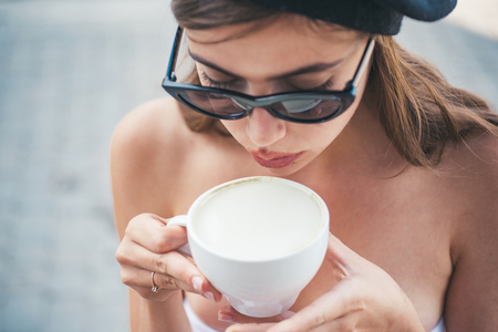 americano or espresso latte of girl. girl relax in cafe and drink. woman drink coffee from cup. perfect morning with best coffee. Enjoying morning coffee. summer day. Starting day with good newsの写真素材