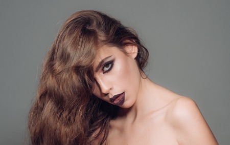 fashion girl with glamour makeup. Fashion portrait of woman. Makeup cosmetics and skincare. woman with fashion makeup and long curly hair.の写真素材