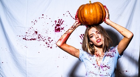 Beautiful Young woman as sexy vampire in blue dress - halloween portrait. Halloween girl with a carved Pumpkin.の写真素材