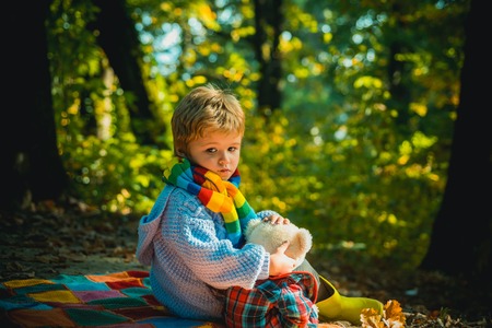 Childrens friendship. Atumn fun at the park. Happy kids autumn. Cute boy with Autumn Leaves on Fall...