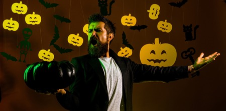 Halloween man with pumpkin in darkness. Happy hipster with bloody beard with pumpkins. Trick or treat. Jack-o-lanterns.の写真素材