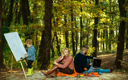 Dad mom and son playing together. Family Camping with kids. We like autumn time together. Happy family having fun in autumn park.の写真素材
