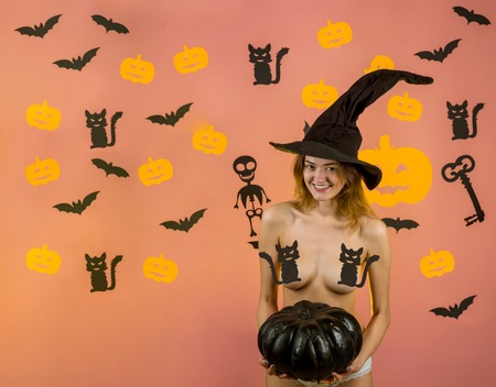 Happy Halloween Sexy Witchs with Big sexy ass. Female with sexy ass posing on pumpkin. Halloween poster with pumpkins. Erotic lady fashion concept. The Most Popular Candy for Halloween.の写真素材