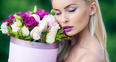 Spring woman enjoing flowers gift from lovely man. Spring look and makeup at beauty day. Womans day and gift on celebration. Gift for woman and happy female concept. 8 march woman. Gift box.の写真素材