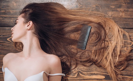 Beautiful brunette girl in move with a perfectly smooth hair. Brunette girl with long and shiny wavy hair. Beautiful model with curly hairstyle. Fashion haircut. Trendy haircuts.の写真素材