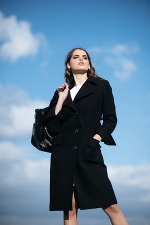 Pretty girl with fashionable hair. Fashion woman with stylish makeup and curly hair. autumn fashion of business woman with bag. Beauty and fashion look. She got great style. Looking trendyの写真素材