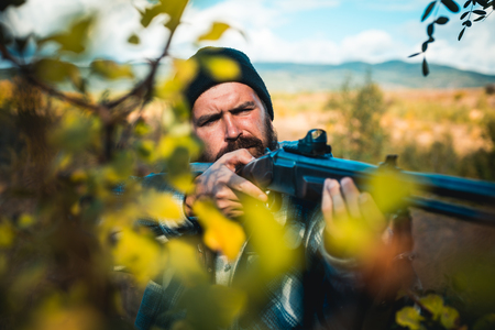 Close up snipers carbine at the outdoor hunting. Man holding shotgun. Hunter with shotgun gun on...