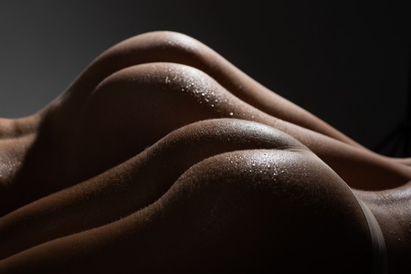 Two beautiful sexy butt close up. Sensual womans ass and her water drops. Big two butt in sensual...