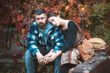 Couple in love in autumn leaves. Laughing bearded man and pretty woman outside. Bearded man and brunette woman with romantic faces on autumn trees background.の写真素材