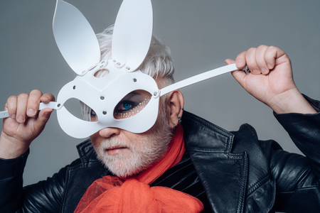 Erotic bunny. Transgender man cover face with rabbit mask. Animal roleplayer. BDSM fashion accessory. Adult sex toys. Male makeup look. Fetish fashion. Heterosexual man with male makeupの写真素材
