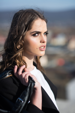 Pretty girl with fashionable hair. Fashion woman with stylish makeup and curly hair. autumn fashion of business woman with bag. Beauty and fashion look. Loving her new style. Young and freeの写真素材
