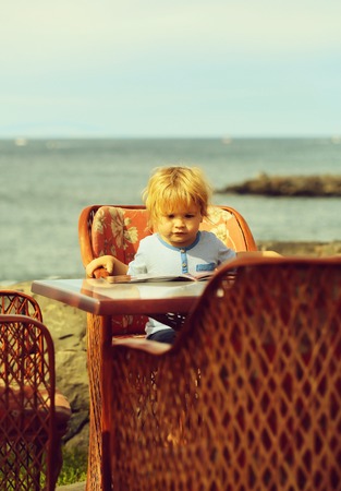 Cute baby boy reads menu cardの写真素材