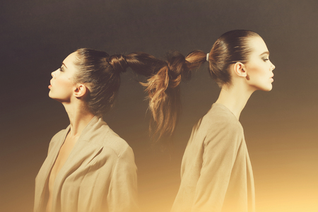 Two cute women with tied long hair into braidの写真素材