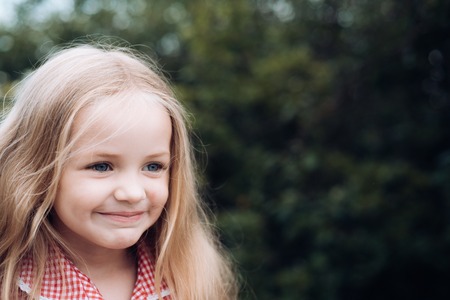With hair flying behind me. Small girl wear long hair. Little girl with blond hair. Happy little child with adorable smile. Small child happy smiling. In a happy moodの写真素材