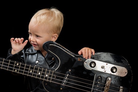 Music festival. Rock style child. Little rock star. Child boy with guitar. Little guitarist in rocker jacket. Rock and roll music performer. Adorable small music fan. Small musicianの写真素材