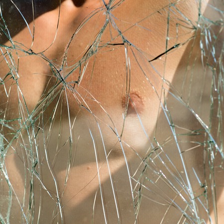 Athletic and muscular. Sport man chest seen through cracked glass. Muscular fit athletic male chest. A male nude, mid section. Sexy strong bare upper torso. Perfect physical abilityの写真素材