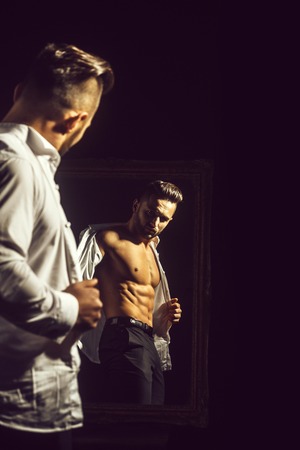 muscular macho man with sexy athlete body near vintage mirrorの写真素材