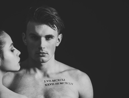 Macho on pensive face with muscular figure, enjoy female attention. Man with muscular torso, macho and female face, dark background. Pheromones, desire and attraction concept.の写真素材