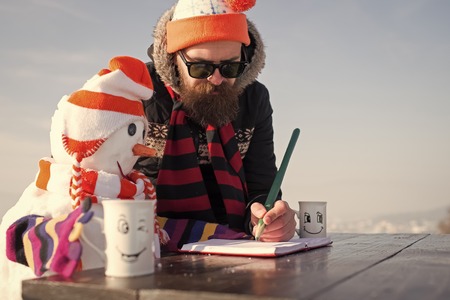christmas man and snowman in hat write in book