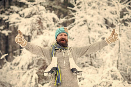 bearded happy man hold skate in snowy winter forest, christmasの写真素材