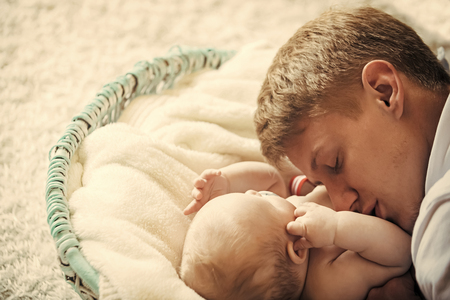 Man and newborn child sleep in crib on floorの写真素材
