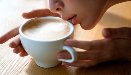 perfect morning with best coffee. fresh morning coffee with milk and cream froth. girl smell aroma...