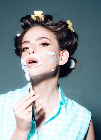 morning grooming and skincare. pinup girl with fashion hair. retro woman shaving with foam and razor blade. pin up woman with trendy makeup. pretty girl in vintage style. Feeling fresh after shavingの写真素材