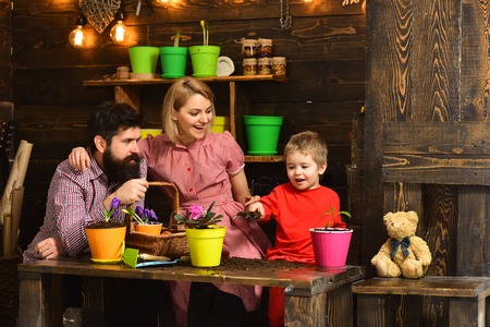 Protection concept. Little child help mother and father to protect flower, protection. Mother and father with son provide protection for houseplant. Child protectionの写真素材