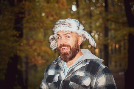 Portrait of young bearded man in grey hat in autumn park. Happy young man are preparing for autumn...