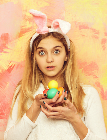 happy easter girl in bunny ears with colorful painted eggsの写真素材