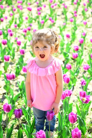Spring everywhere. face and skincare. allergy to flowers. Small child. Natural beauty. Childrens day. Little girl in sunny spring. Summer girl fashion. Happy childhood. Springtime tulips.の写真素材